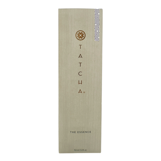 A tall, slim bottle of Tatcha The Essence Plumping Skin Softener with a beige label and a small decorative pattern on the lower right corner.